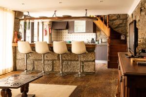 una cocina con encimera y algunas sillas blancas en Casa da Eira - Alojamento Local, en Braga