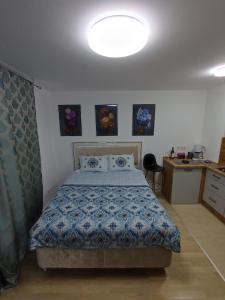 1 dormitorio con 1 cama con edredón azul en Passion by Nights & Smiles en Tuzla