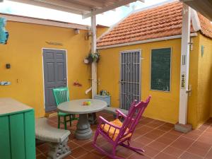 a patio with a table and chairs in front of a house at La Bamba in Willemstad