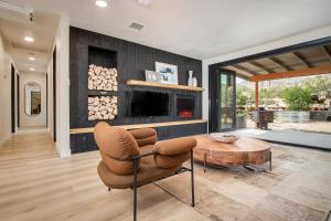 a living room with a chair and a table and a fireplace at @ Marbella Lane - The Wine Mine Desert Escape in Joshua Tree