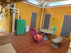 een patio met stoelen en een tafel voor een huis bij La Bamba in Willemstad