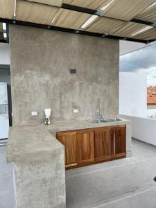 a kitchen with a sink and a stone wall at Ancla Baja Living Condominio nuevo con vista 1 in La Paz