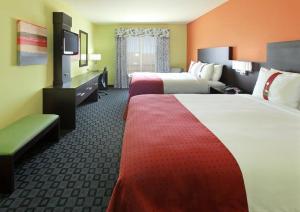 a hotel room with two beds and a flat screen tv at Holiday Inn Garland, an IHG Hotel in Garland