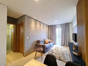 a living room with a couch and a tv at Apartamento Prime Master Collection in Passo Fundo