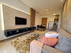 a living room with a couch and a flat screen tv at Apartamento Prime Master Collection in Passo Fundo