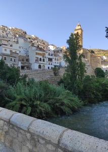 ein Fluss vor einer Stadt mit Gebäuden in der Unterkunft El Mirador 3 in Alcalá del Júcar + 13 Fotos