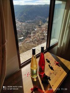 zwei Flaschen Wein auf einem Tisch vor einem Fenster in der Unterkunft El Mirador 3 in Alcalá del Júcar