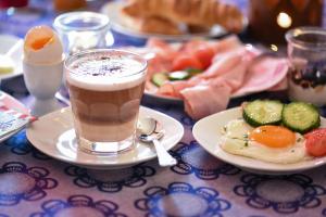 a table topped with a plate of food with a drink at Pension Froschkönig in Forchheim