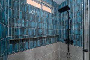 a bathroom with a shower with blue tiles at @ Marbella Lane - Rainbow House Glampers Paradise in Joshua Tree