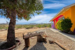 a bench next to a tree next to a building at @ Marbella Lane - Rainbow House Glampers Paradise in Joshua Tree