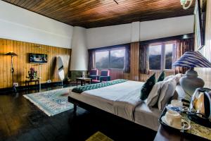 大吉岭Central Gleneagles Heritage Resort Former Bungalow of Ex-TATA Chairman Russi Mody The Mall Road Darjeeling的一间带窗户的房间里有一张大床的卧室