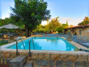 a large swimming pool with a stone wall around it at THE MANSION in yesod hamaala in Yesod Hamaala