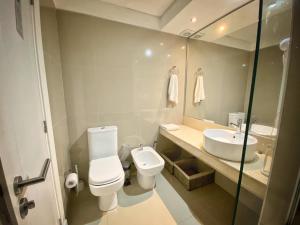 a bathroom with a toilet and a sink and a mirror at Green Park Solanas 2 ambientes en PB Excelente vista in Punta del Este +14 photos