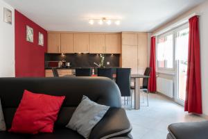 a living room with a couch and a kitchen at Haus Aurora in Saas-Grund