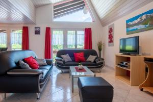 a living room with two couches and a tv at Haus Aurora in Saas-Grund