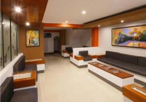 a waiting room with couches and paintings on the wall at Hotel Plaza in Tacna