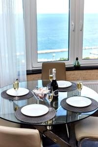 uma mesa de vidro com cadeiras e copos de vinho em Pearl of Arcadia on Kamanina em Odessa