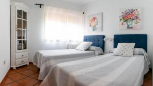 sypialnia z 2 łóżkami i oknem w obiekcie La Casita de las Hortensias w mieście Ortigosa del Monte