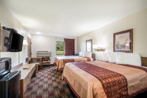 Habitación de hotel con 2 camas y TV de pantalla plana. en Americas Best Value Inn & Suites Harrisonville, en Harrisonville