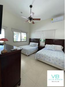 a bedroom with two beds and a ceiling fan at Villa Bianca Bacalar in Bacalar