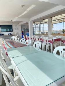 Habitación con mesa y sillas blancas. en Hospedaje Anais, en Pisco