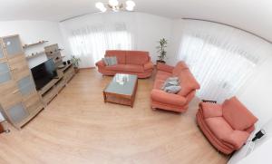 einen Blick über ein Wohnzimmer mit orangefarbenen Möbeln in der Unterkunft A house, free parking, sauna in Koprivnica