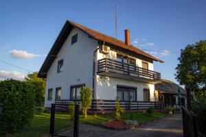 ein weißes Haus mit einem Zaun davor in der Unterkunft A house, free parking, sauna in Koprivnica