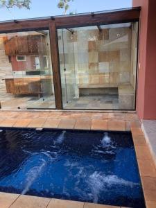 - une piscine en face d'une maison dans l'établissement Casa na Represa do Broa - Condomínio Vila Pinhal, à Itirapina