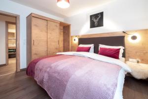 una camera da letto con un grande letto con cuscini rossi di Appart Muchas a Schönwies
