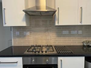 a stove top oven in a kitchen with white cabinets at CityStays Rooms with Free Parking in Liverpool +34 photos