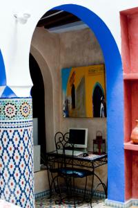 Un arco con una mesa y un ordenador en una habitación en Riad Assilah Chaouen, en Chefchaouen