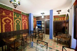 a restaurant with tables and chairs and colorful walls at Riad Assilah Chaouen in Chefchaouene