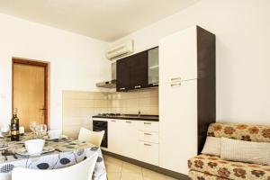 een keuken en eetkamer met een tafel en stoelen bij Sladana direct at the beach in Metajna +37 foto's