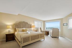 a bedroom with a bed and a chair and windows at @ Marbella Lane - Oceanfront w/ unobstructed views!! in Pacifica