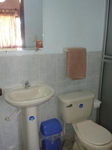a bathroom with a toilet and a sink at Hotel Piesta in Trinidad