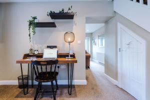 a home office with a desk and a laptop on it at Castle Views cottage in historic village & woodfired hot tub in Rhuddlan