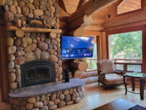 uma sala de estar com uma lareira de pedra e uma televisão em Amazing Cabin em El Cajon