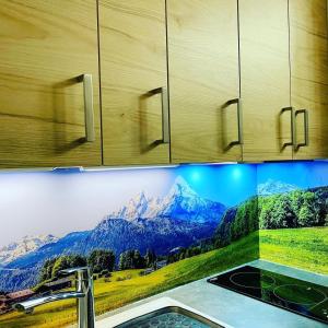 uma cozinha com um lavatório com uma imagem na parede em L'AnsloBoys Montagne H2 em Les Deux Alpes