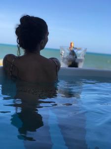una mujer en una piscina mirando a un hombre en un barco en Pousada Yemanjá Toré en Barra de Camaratuba