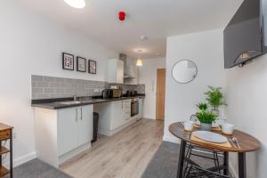 a kitchen with a table and a counter top at Charles Alexander Short Stay - Charnley House Apartments in Blackpool