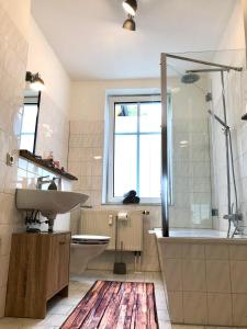 uma casa de banho com um lavatório, uma banheira e um chuveiro em Apartment Zum grauen Wolf em Erfurt
