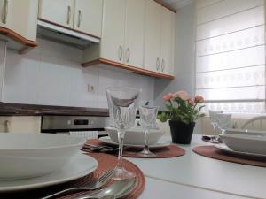 a kitchen with a table with plates and glasses on it at Arrantzale Beach in Bermeo