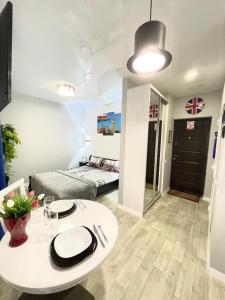 - un salon avec une table et un lit dans l'établissement Apartment Studio LONDON 92, à Irpin