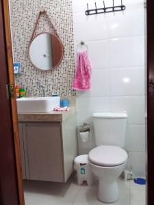 a bathroom with a toilet and a sink and a mirror at CASA NO CONDOMÍNIO CAMINHO DA SERRA in Bananeiras