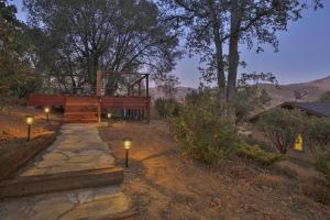 a house with a staircase and lights in the yard at Whispering Pines Lookout in Oakhurst
