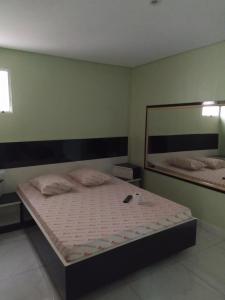 a bedroom with a bed and a large mirror at Hotel Progresso in Curitiba