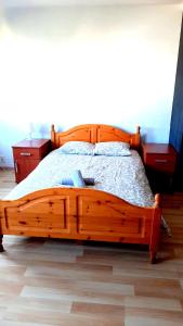 a wooden bed in a bedroom with a wooden floor at Smart Rooms Poznan in Poznań