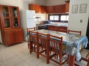 a kitchen with a table with chairs and a refrigerator at Residencial Niágara in Arroio do Sal