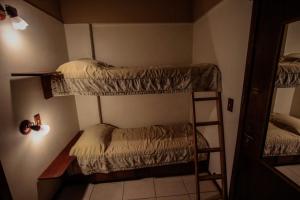 a room with two bunk beds and a mirror at Residencial Pousada do Serrano - 1 quarto in Gramado