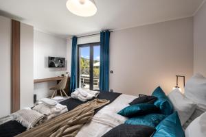 a bedroom with a large bed with blue pillows at Villa Castanea in Opatija